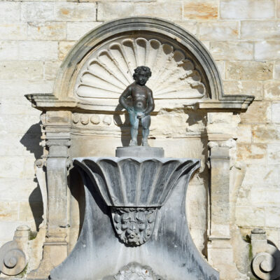 Het Manneken-Pis van Geraardsbergen is een bekend beeldje in Geraardsbergen. De inwoners van Geraardsbergen plaatsten het beeld van een plassende jongen in 1459 op een fontein, ter vervanging van een door Gentenaars gestolen beeld van een leeuw. De stad was in 1452 verwoest. Voor het herstel van de waterhuishouding deed Geraardsbergen een beroep op de Brusselse fonteinmeester Jan van den Schelden, die in 1455 de opdracht kreeg een lattoenen mannekin te maken. Het werd in mei 1459 opgeleverd door de Brusselse geelgieter Reinier I van Tienen. Het huidige beeldje aan de trappen van het stadhuis is een kopie van het oorspronkelijke beeldje uit 1459, dat men kan bewonderen in De Permanensje, waar ook het toeristisch infokantoor is ondergebracht. De kopie dateert van 1985. Het Broederschap animeert de tweestrijd tussen Geraardsbergen en Brussel (zie het meer gekende Manneken Pis van Brussel), die draait om de vraag wie nu het oudste beeldje zou bezitten. De oorsprong van het Geraardsbergse ventje vindt men terug in de stadsrekeningen van 1455 en 1459 die te raadplegen zijn in het Algemeen Rijksarchief. De naam Manneken Pis is in Brussel al sinds 1452 in gebruik en daardoor is de traditie van het Manneken Pis in Brussel ouder dan deze van Geraardsbergen. Het bekende Brusselse beeldje dateert echter van 1619, en om die reden claimt men in Geraardsbergen het oudste Manneken te hebben.