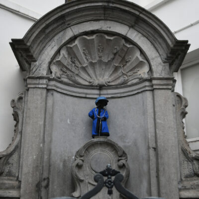 Brussel bezoeken is ook langs Manneken Pis gaan. Kostuum van het kapittel van de jaarlijkse studenten cirkel ISIM's Bergen. Manneken Pis is een standbeeldje van een plassend jongetje in het centrum van Brussel. Het 55,5 cm grote ventje op een sokkel is geplaatst aan de hoek van de Stoofstraat en de Eikstraat, niet ver van de Grote Markt. Het is uitgegroeid tot een van de beroemdste Belgische en Brusselse monumenten en een symbool/mascotte van de stad Brussel. Behalve het Manneken Pis van Brussel zijn er ook in Geraardsbergen, Westmeerbeek, Broksele en Koksijde, maar dat van Brussel is het bekendste. Het is een bronzen creatie van Hiëronymus Duquesnoy uit 1619. 